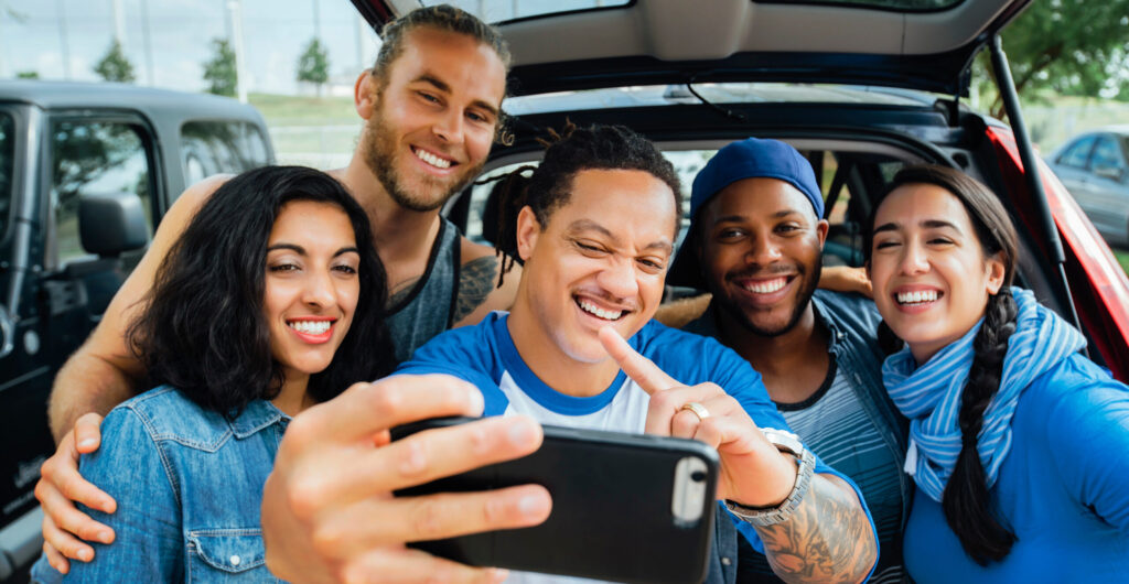 A group of friends taking a selfie at a tailgate event, enjoying the pre-game festivities with smiles and excitement.